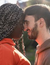 A romantic multiracial couple close forehead to forehead