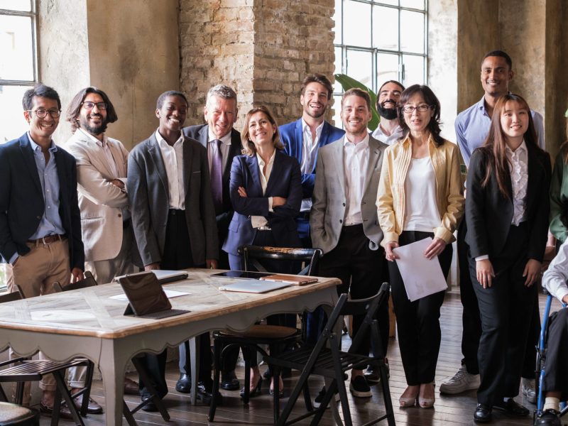 Team photo of businesspeople standing in coworking space